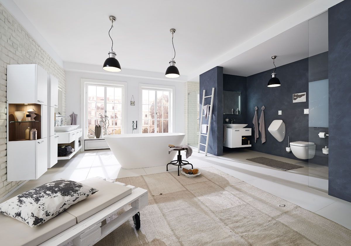 Ein modernes Badezimmer mit einer Liege, weißer Badewanne und einem weißem Waschbecken.